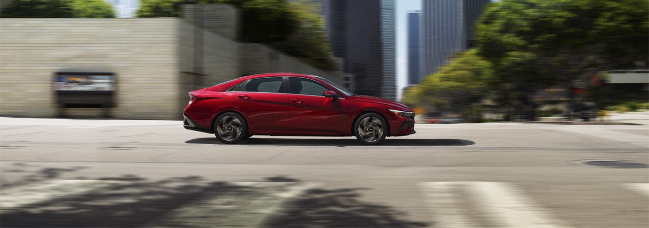 2025 Hyundai Elantra at West Broad Hyundai | Side profile of a 2025 Hyundai Elantra driving down the road