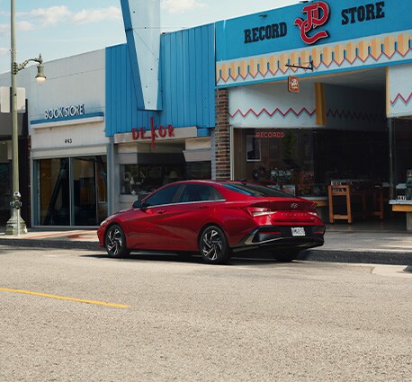 2025 Hyundai Elantra at West Broad Hyundai | Rear profile of a Red 2025 Hyundai Elantra parked on the side of a street