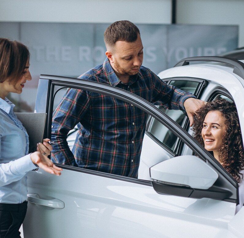 Why drivers should consider an extended warranty on their Hyundai at West Broad Hyundai | Woman sitting in the passenger side of car while talking to sales person