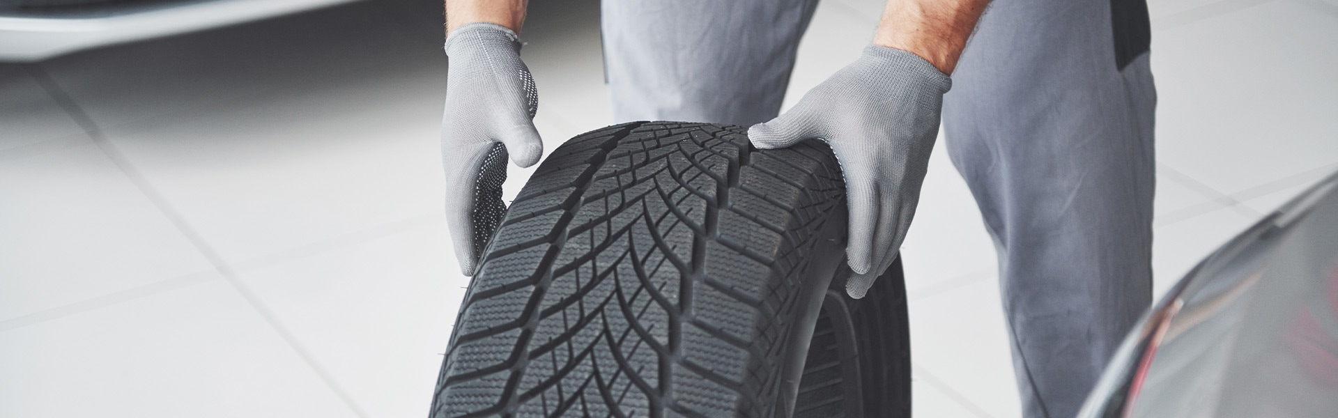 what different tire options are available at West Broad Hyundai in Richmond | Service Advisor Rolling Tire on Service Bay Floor