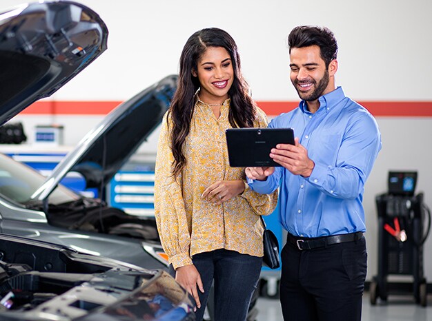 Everything You Need to Know about Your Car Battery at West Broad Hyundai | Sales representative showing a customer important information of car battery by showing his iPad