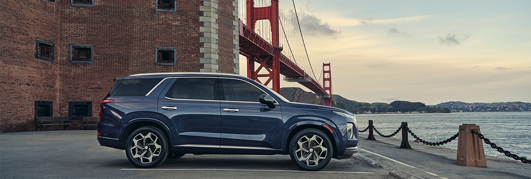 Compare the 2021 Hyundai Palisade vs. the 2021 Toyota Highlander at West Broad Hyundai | Palisade parked next to big red bridge