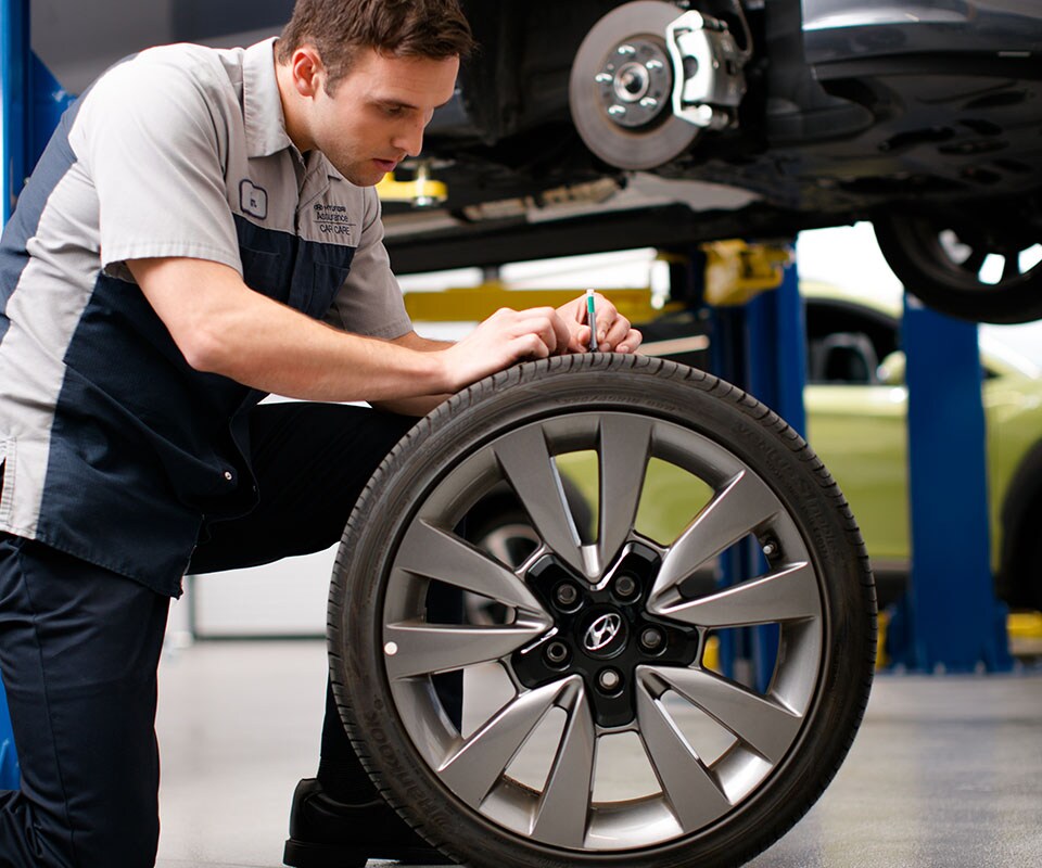 Tips for spring cleaning your car at West Broad Hyundai in Henrico, VA | Hyundai Technician Checking Tire Tread Depth
