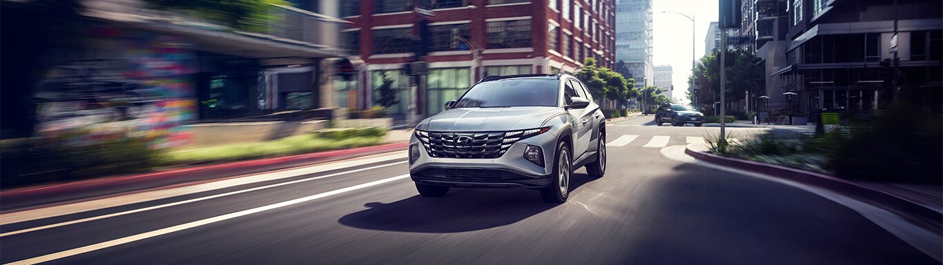 Best MPG At West Broad Hyundai in Henrico, VA | Grey 2023 Hyundai Tucson driving down a city road during the day