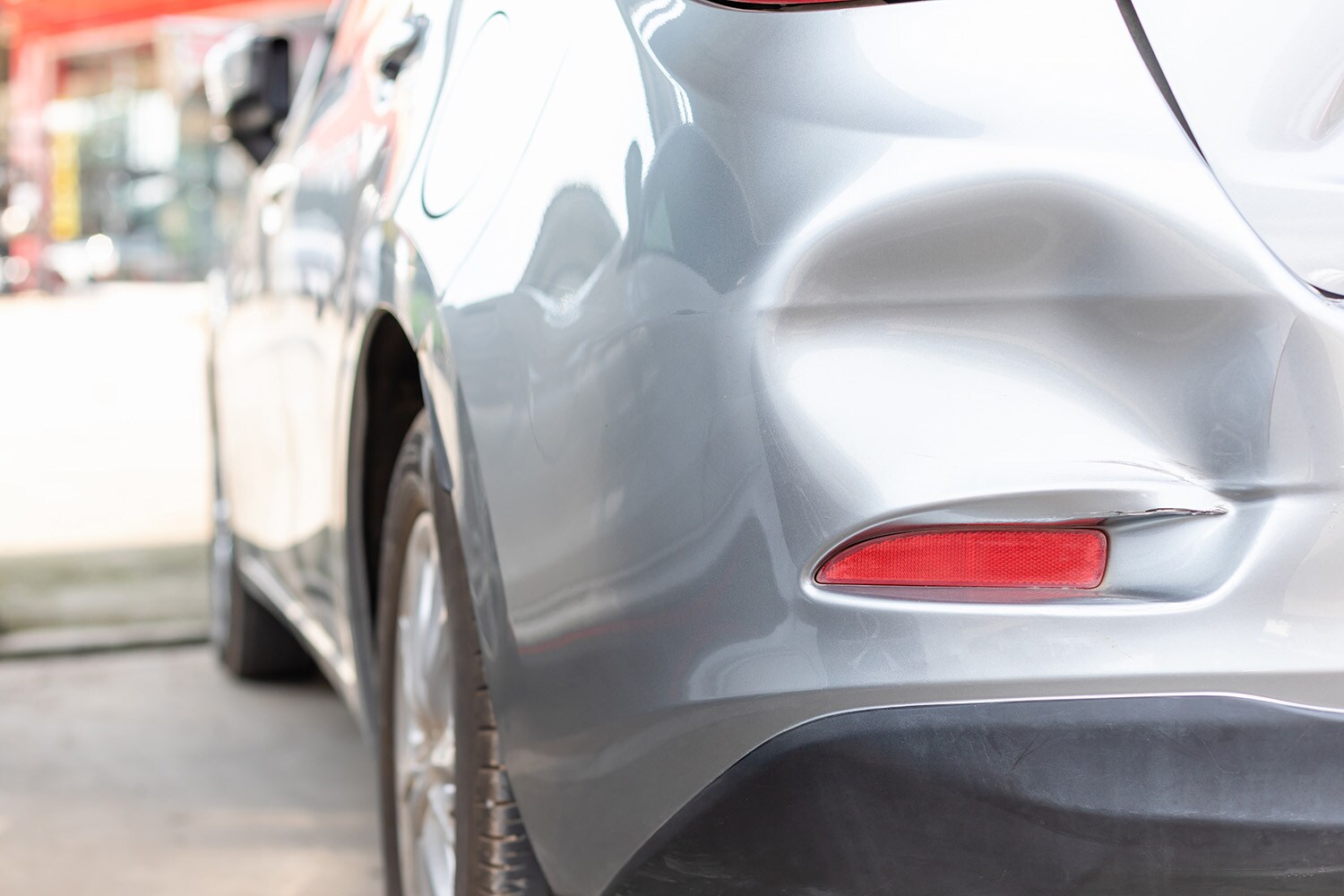 What is Paintless Dent Repair? | West Broad Hyundai | A dent on a silver vehicle's bumper that can be repaired using paintless dent repair
