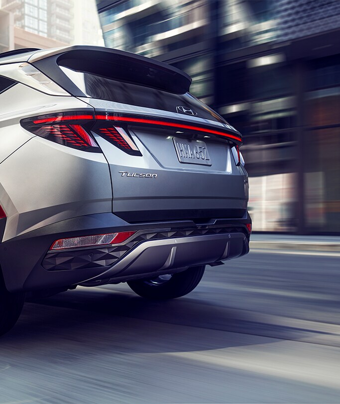 Best MPG At West Broad Hyundai in Henrico, VA | Rear view of a Grey 2023 Hyundai Tucson driving down city road