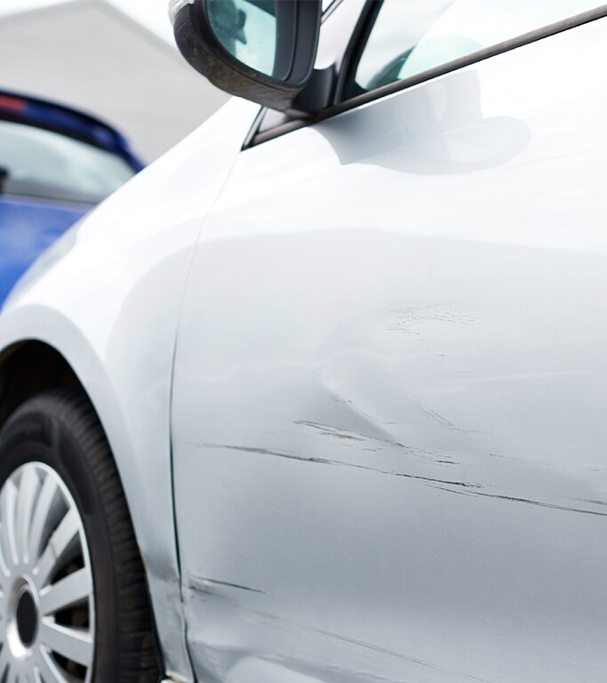 What is Paintless Dent Repair? | West Broad Kia | White car with small dent and small scratches