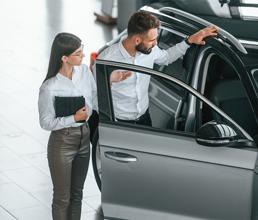 Why drivers should consider an extended warranty on their Kia at West Broad Kia | Customer checking out the passenger side of a new car