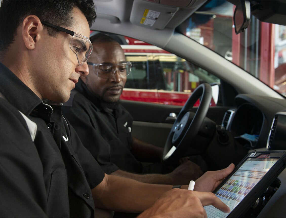 What is included in a Multi-Point Inspection? | West Broad Kia in Richmond | Service Technicians Looking at Tablet While Sitting in Car