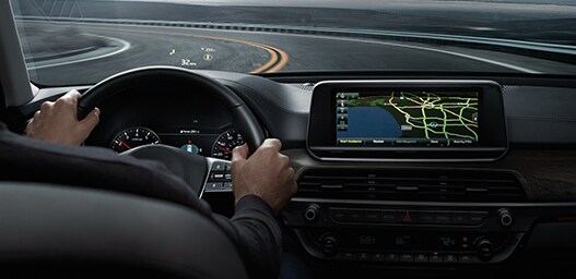 Compare the 2021 Kia Telluride vs. the 2021 Honda Pilot at West Broad Kia | Guy driving with dash board navigation