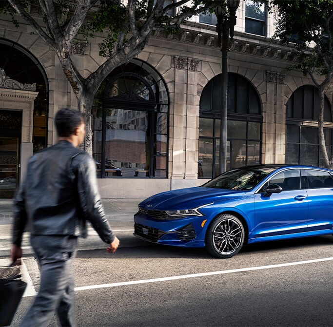 Best MPG At West Broad Kia in Henrico, VA | Man walking up to his parked 2023 Blue Kia K5