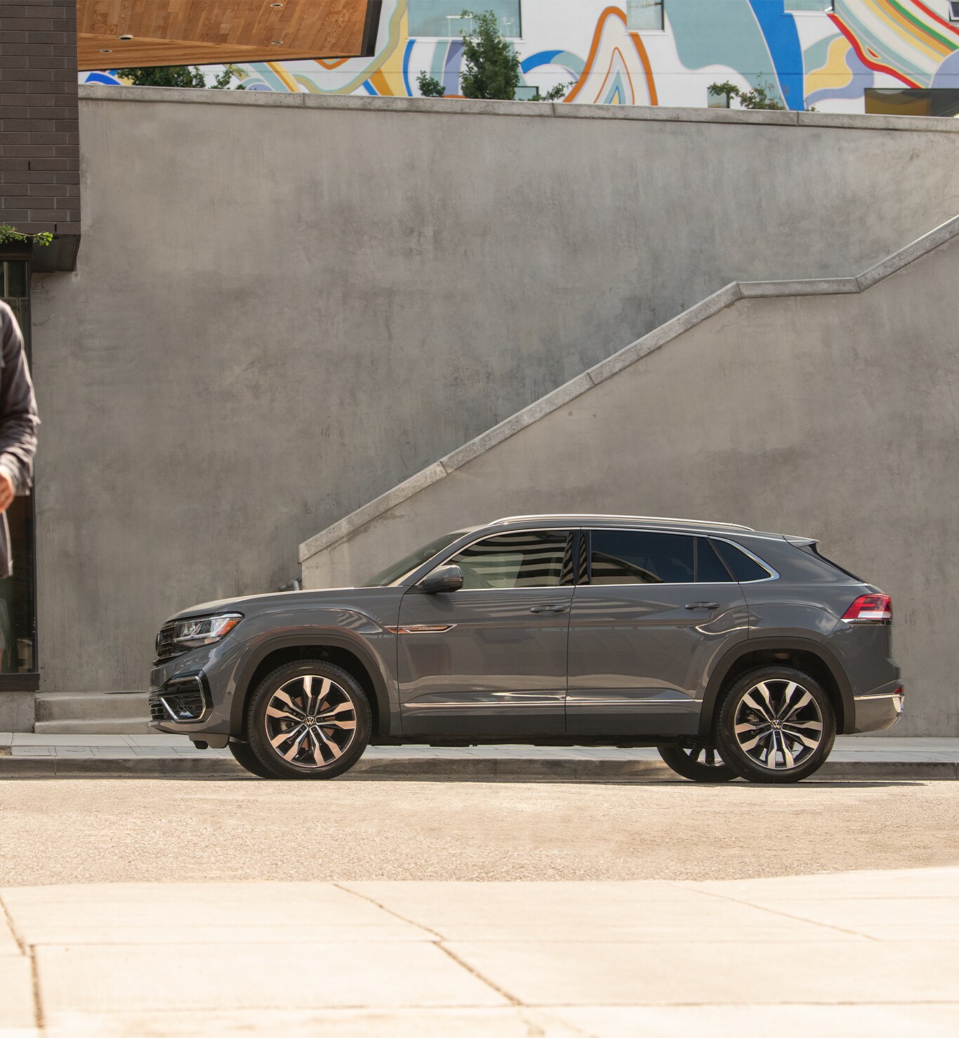 Model Features of the 2022 Volkswagen Atlas at West Broad Volkswagen | Side view of a Matte Grey Volkswagen Atlas parked by the side of the road with a staircase behind it