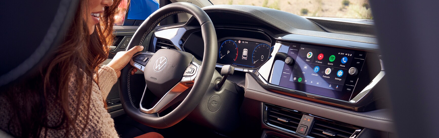 Android Auto vs. Apple CarPlay at West Broad VW in Richmond, VA | Woman driving her Volkswagen Passat with Android Auto displayed on center console