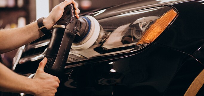 How to Get Your Car Summer Ready at West Broad VW in Richmond, VA | Person using polisher machine to polish volkswagen car headlight