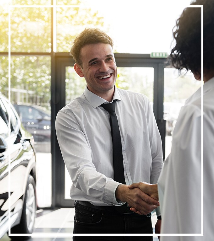 How to Prepare to Trade in Your Car | West Broad VW in Richmond, VA | Man shaking hands with sales person inside of dealership