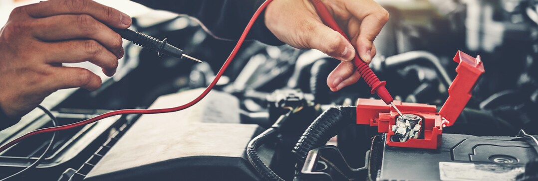 Battery Information at West Broad Volkswagen | Close-up on mechanic testing car battery