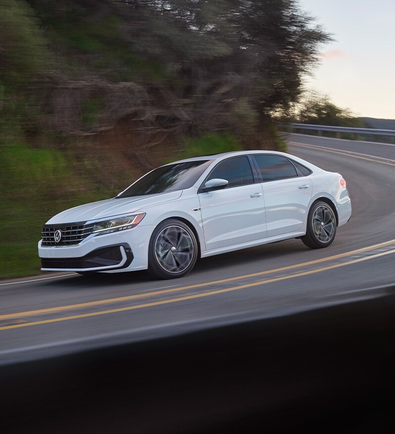 What Different Tire Options are Available at West Broad Volkswagen in Richmond | 2021 Volkswagen Passat Driving Around Bend Past Trees