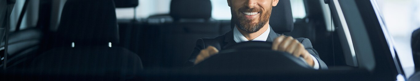 Enjoy A Test Drive At West Broad VW in Richmond, VA | Man smiling while driving in his new car with black interior
