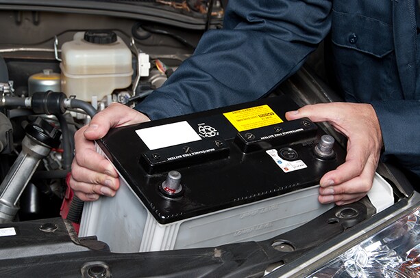 How to prepare your Volkswagen for the winter season in Richmond, VA at West Broad VW | Mechanic putting in new car battery into engine bay