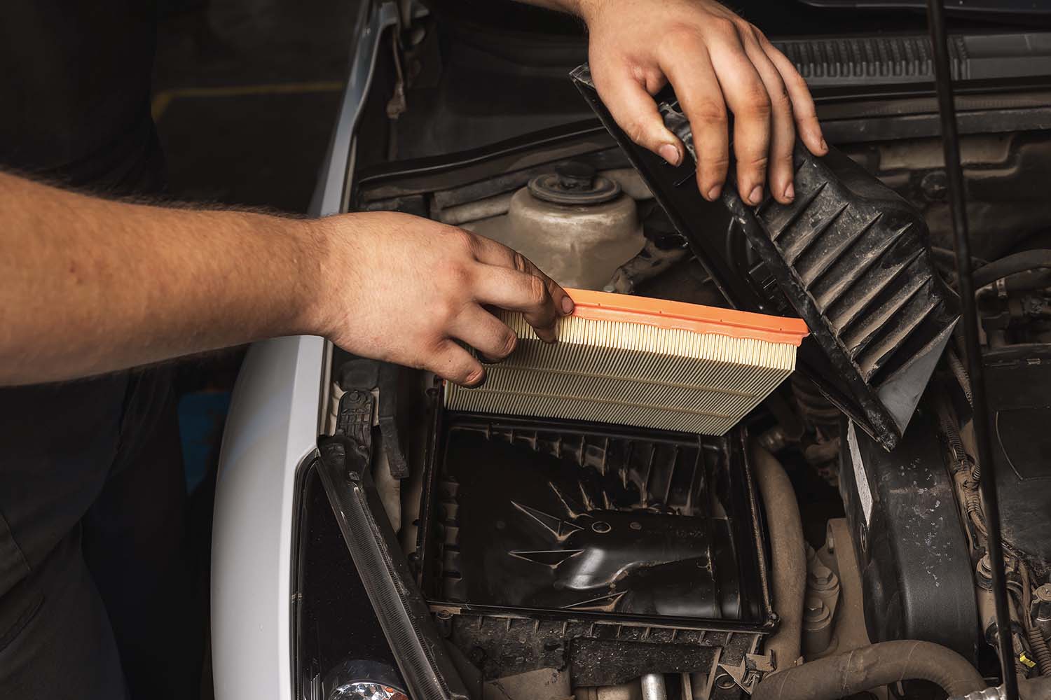 Tips for spring cleaning your car at West Broad Volkswagen in Richmond, VA | Man putting in new air filter for his vehicle