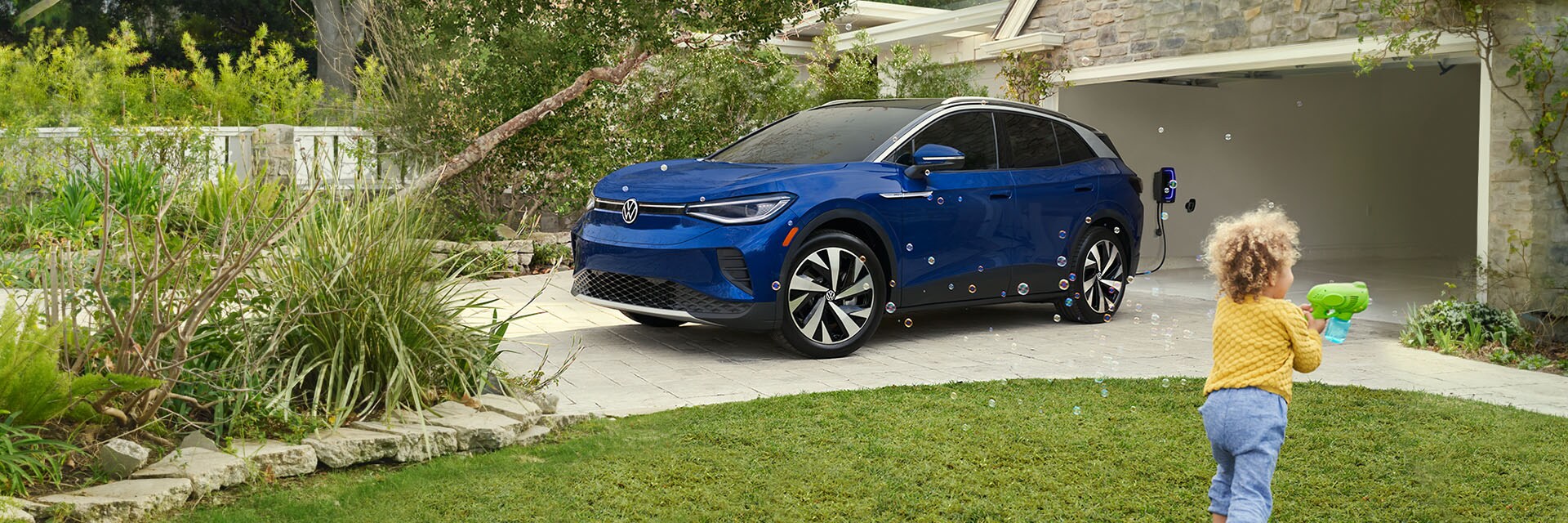 Accessories that help keep your Volkswagen protected at West Broad Volkswagen in Richmond, VA | Blue Volkswagen D.4 Parked in Driveway with Child Blowing Bubbles in Front of Vehicle