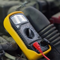 Battery Information at West Broad Volkswagen | Voltage tester for battery is placed on engine bay