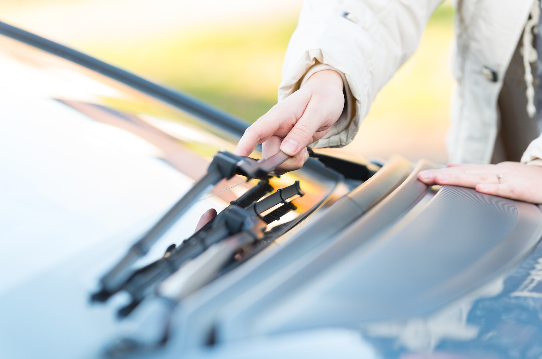 Person installing new windshield wipers.