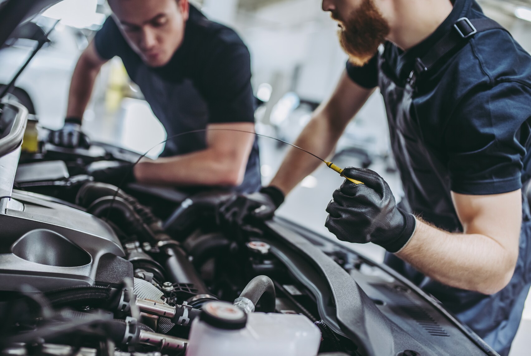 Certified technicians changing car's oil.