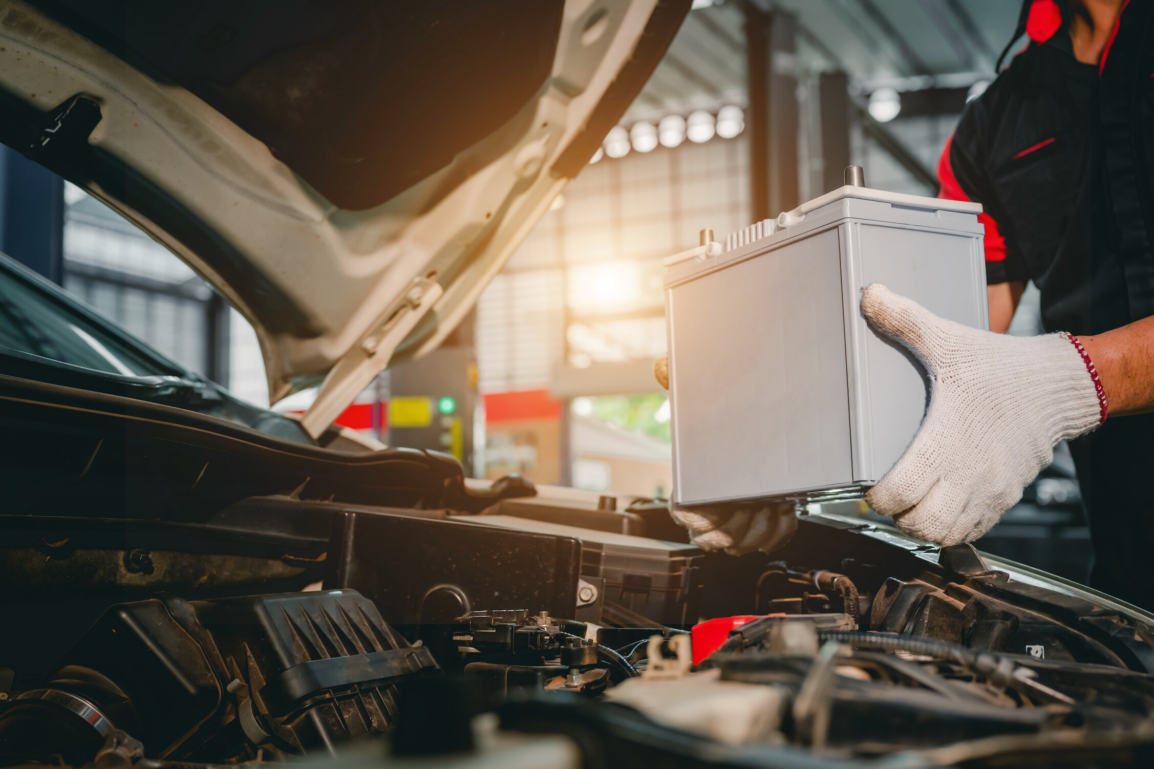 Mechanic replacing a car battery.