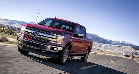 A 2018 Ford F-150 A red 2018 Ford F-150 driving towards the viewer