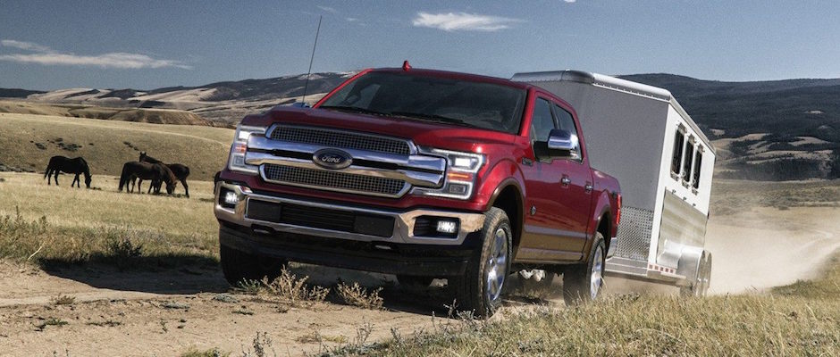Ford Reliability A Ford F-150 towing a trailer down a dirt road