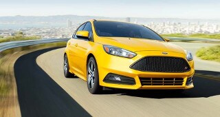 Ford Focus Model Research A yellow Ford Focus driving down the highway