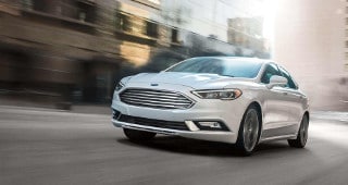 Ford Fusion Model Research A white Ford Fusion driving through the city