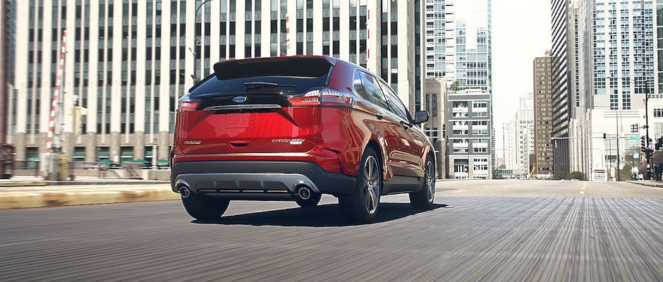 Stay updated on the 2019 Ford Edge A red 2019 Ford Edge driving into the city