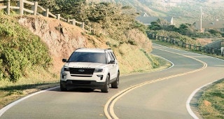 Ford Explorer Model Research A white Ford Explorer driving through the country road