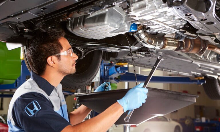 Honda Service Mechanic Under Car With Wrench
