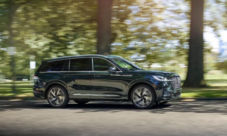 2025 Lincoln Aviator driving past trees