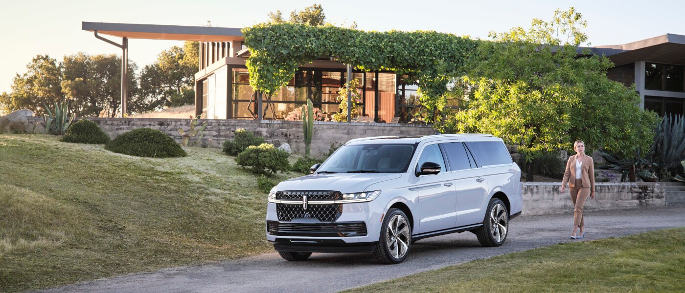 2027 Lincoln Navigator outside a home with woman