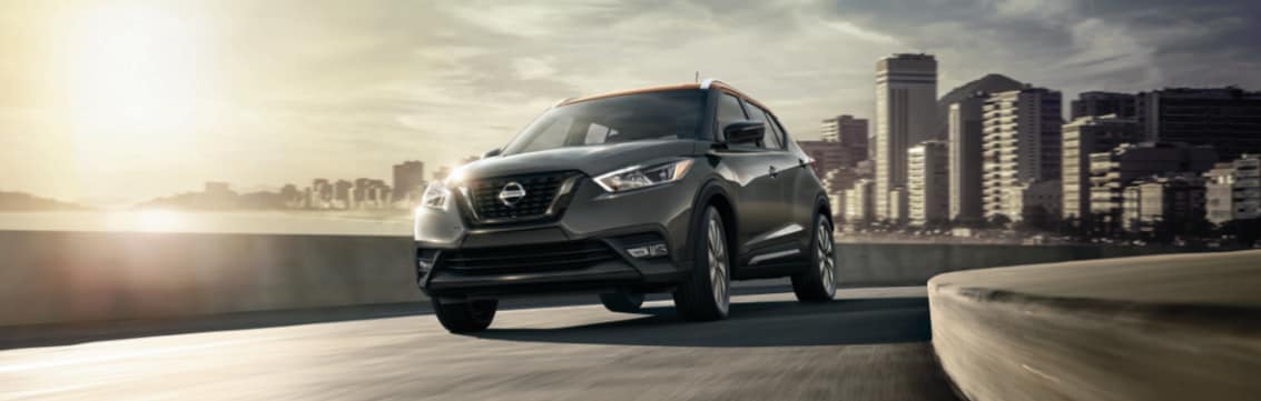 nissan kicks driving away from city