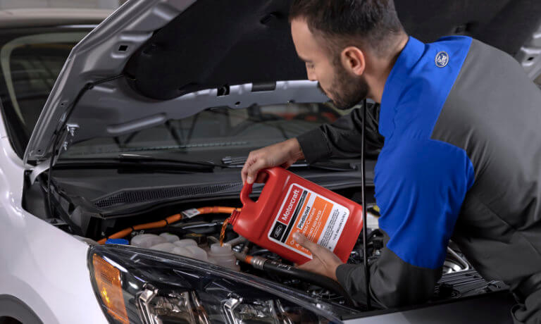 Ford Mechanic pouring oil