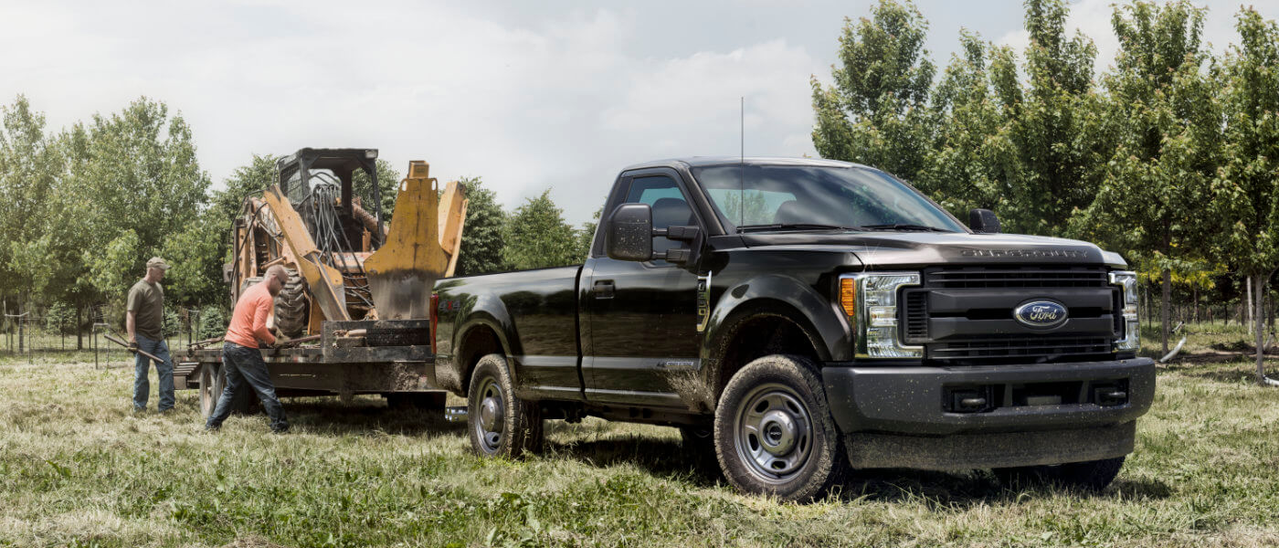 2019 Ford F-350 exterior loading construction tractor in field