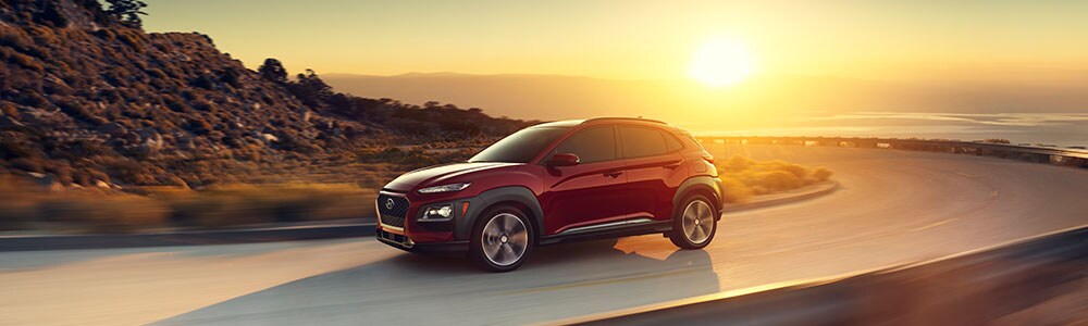 New Hyundai Kona driving on the road at sunset