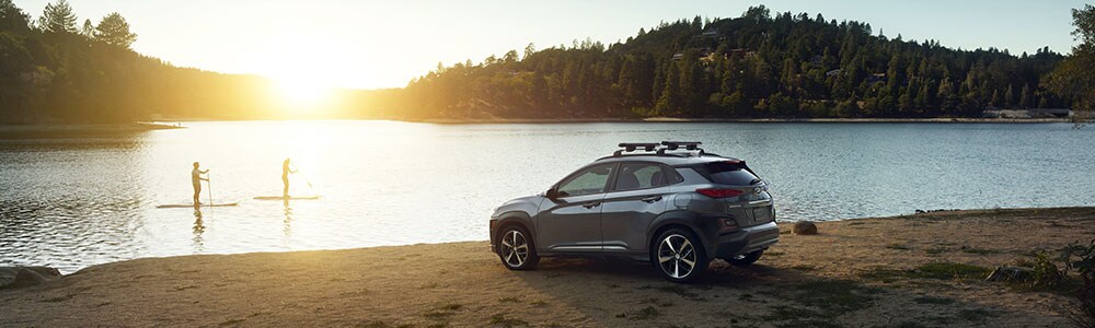 New Hyundai Kona at the lake with paddle boarders in the distance