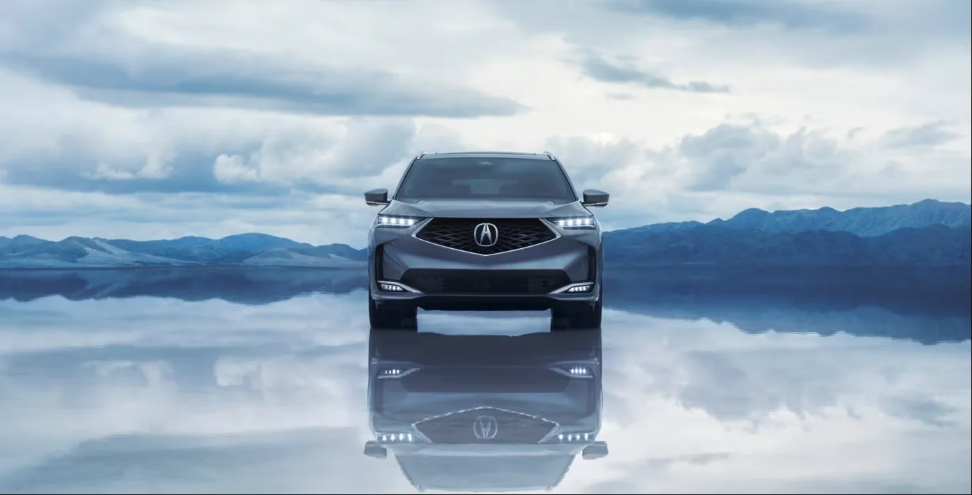 Front view of a 2026 Acura MDX on a reflective landscape