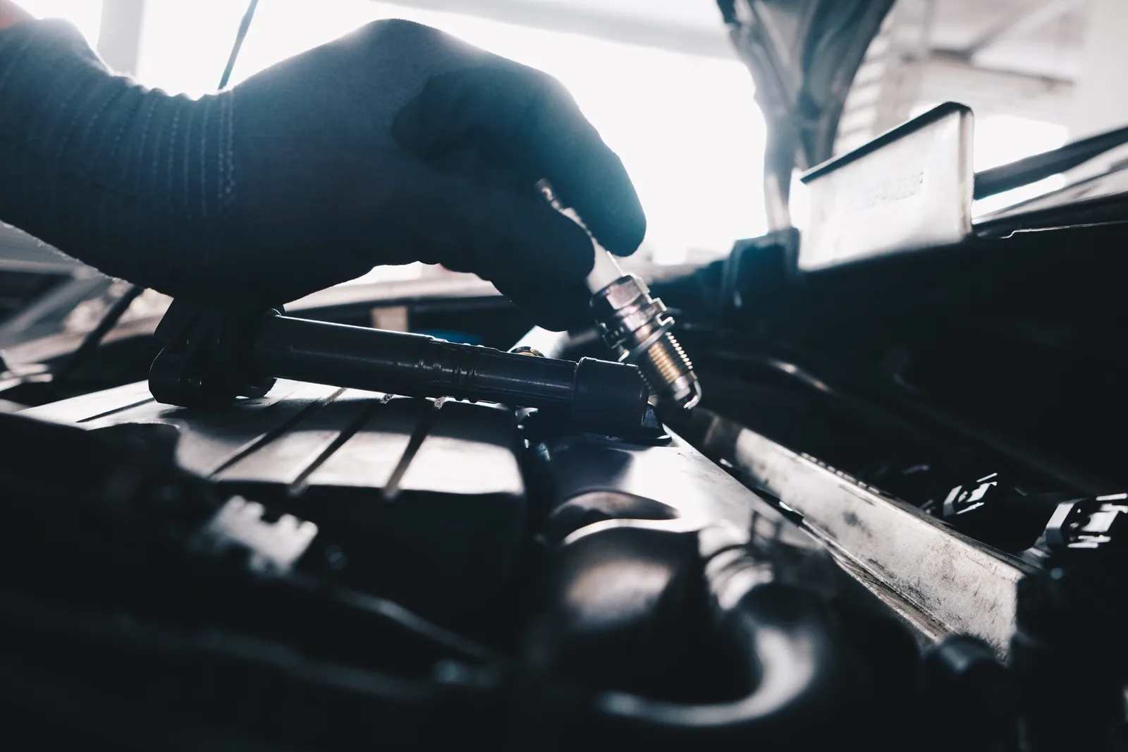 Technician handling a spark plug during engine service