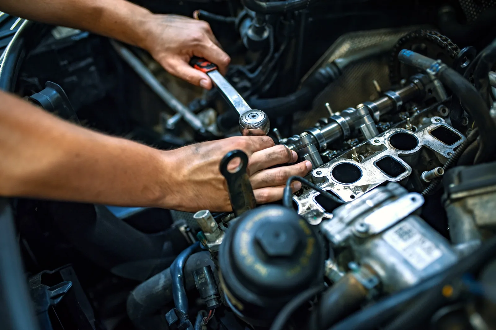 Technician working inside an engine bay during advanced engine service