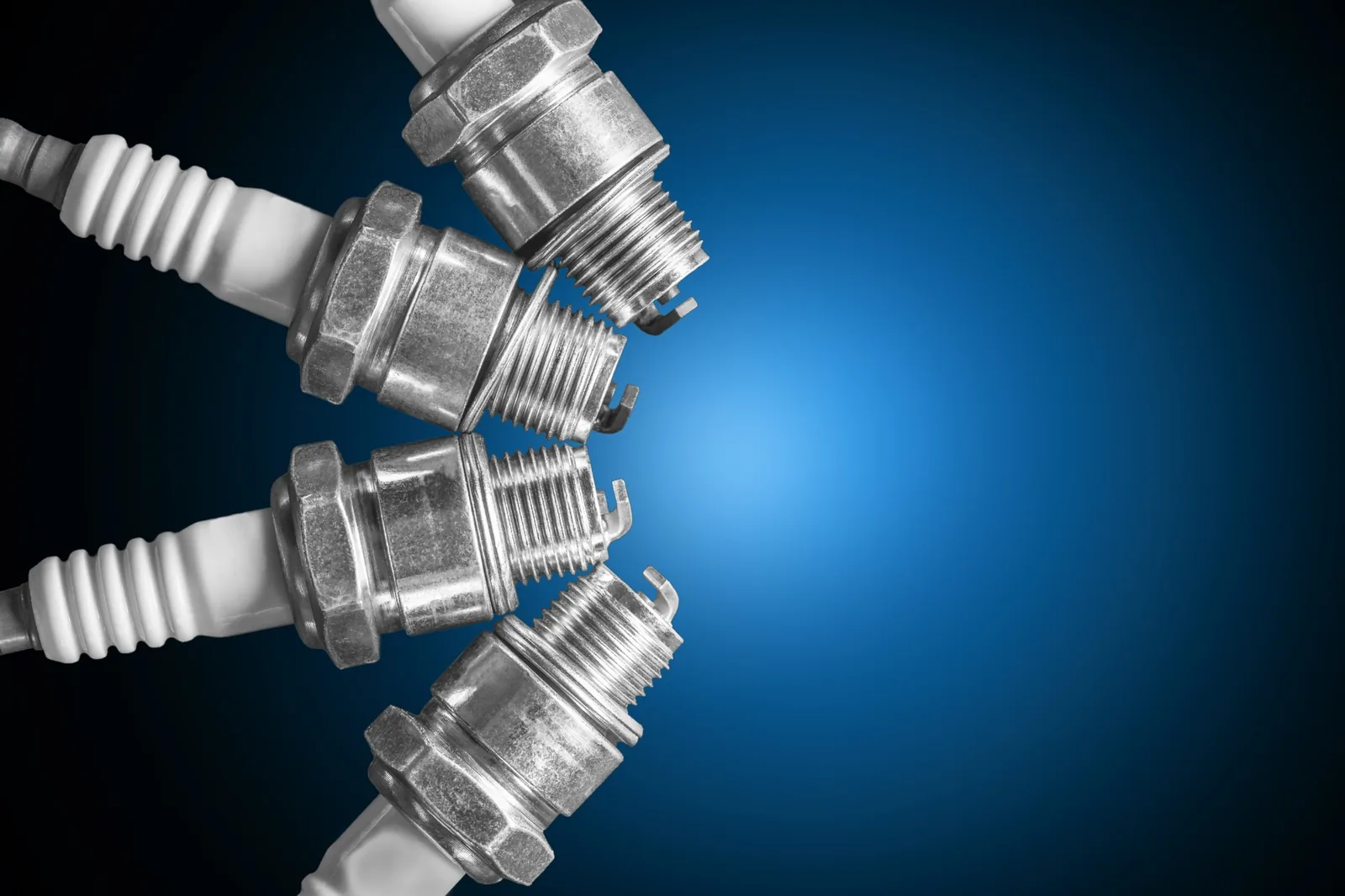 Spark plugs arranged against a dark blue background