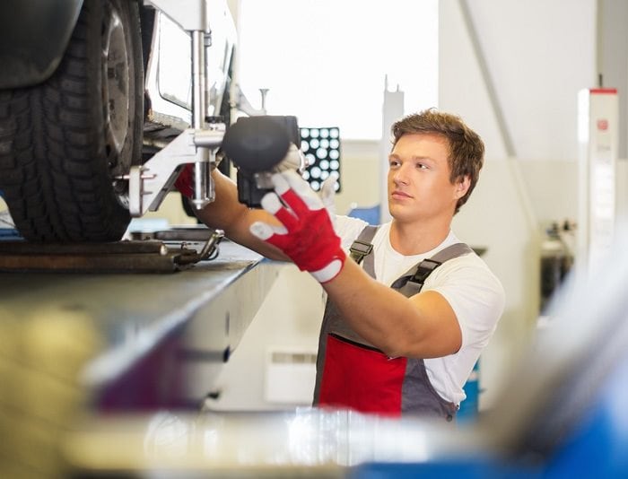 Technician performing a wheel realignment