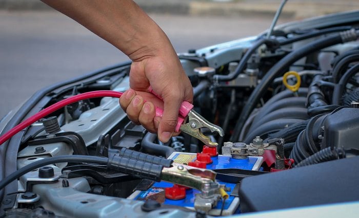 attaching jumper cables to a car battery