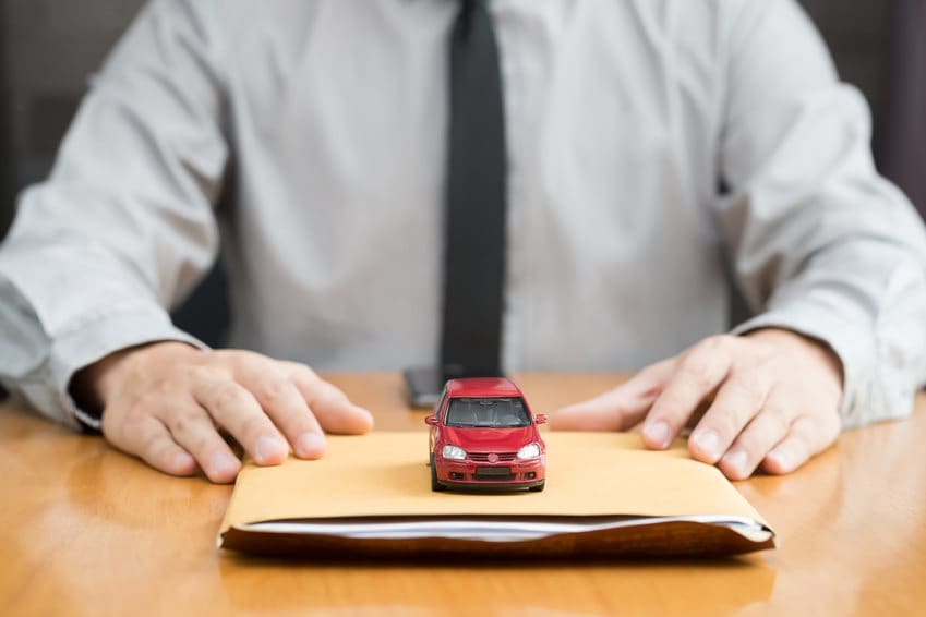 man with a folder of paperwork and a toy car